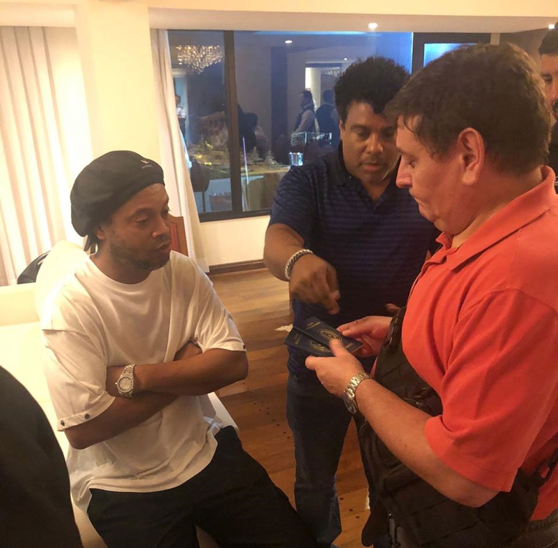 epa08270841 A handout photo made available by the Paraguayan Prosecutor's Office shows former professional soccer player Ronaldinho (L) surrounded by paraguayan authorities as they search his hotel room in Asuncion, Paraguay, 04 March 2020, Paraguay, 04 March 2020. The Paraguayan Prosecutor's Office ordered the arrest of Ronaldinho for alleged possession of altered passports, hours after the Brazilian former player entered Paraguay. Ronaldinho was allowed to remain in his hotel under custody.  EPA/PARAGUAYAN PROSECUTOR’S OFFICE H HANDOUT/EDITORIAL USE ONLY/NO SALES/BEST QUALITY AVAILABLE HANDOUT EDITORIAL USE ONLY/NO SALES
