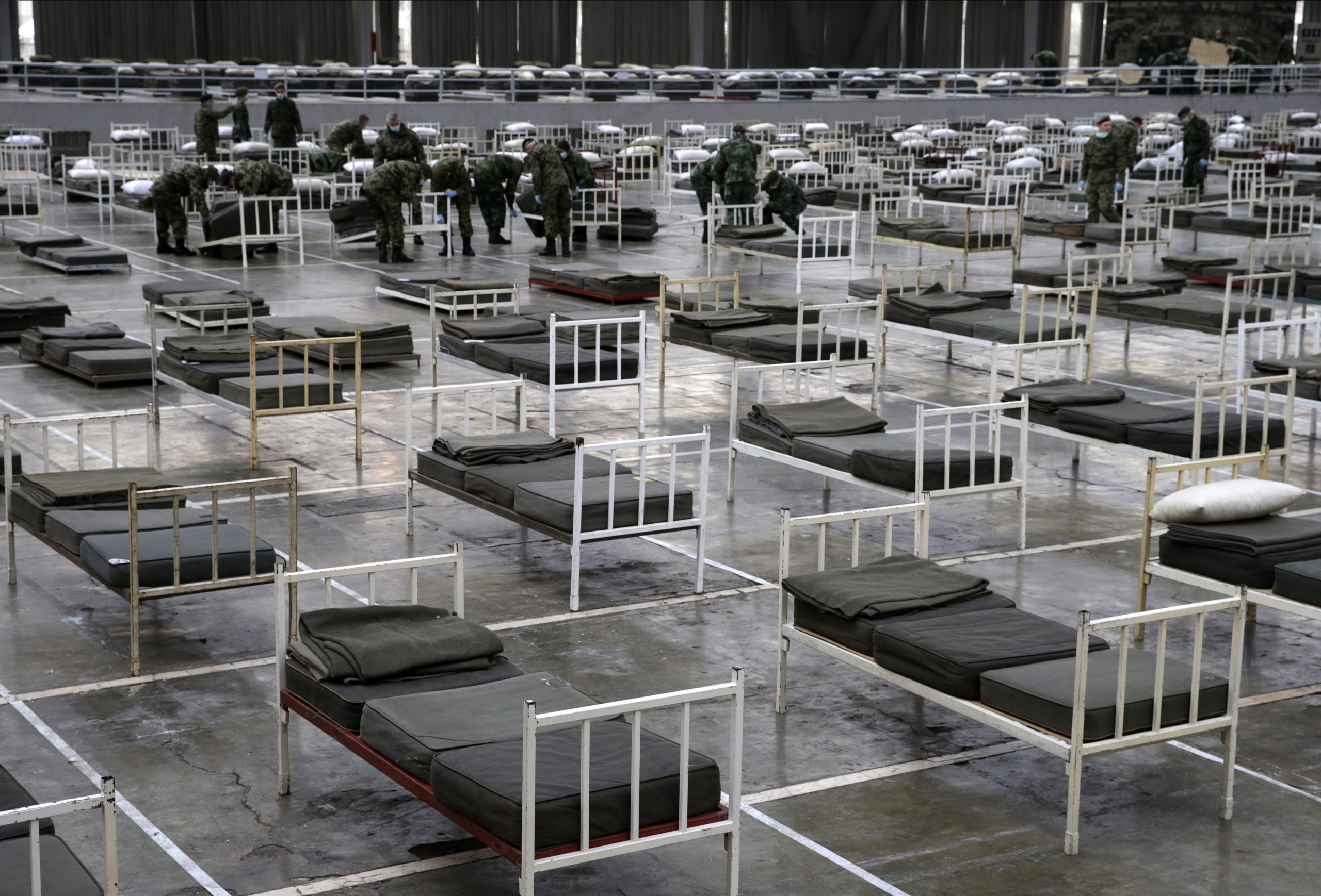 epa08318074 Serbian army soldiers prepare beds for people infected with the coronavirus SARS-CoV-2 at the Belgrade Fair, in Belgrade, Serbia, 24 March 2020. The Serbian authorities declared the state of emergency on 15 March 2020 over the ongoing coronavirus Covid-19 pandemic. Several European countries have closed borders, schools and public facilities, and have cancelled major sports and entertainment events in order to prevent the spread of the coronavirus SARS-CoV-2 which causes the Covid-19 disease.  EPA/ANDREJ CUKIC