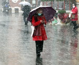 epa08334216 People wearing face masks hold up umbrellas to shield themselves from heavy snowfall in Sarajevo, Bosnia and Herzegovina, 31 March 2020. According to latest figures by WHO on 30 March, a total of 325 cases of coronavirus are confirmed in Bosnia and Herzegovina, and six deaths.  EPA/FEHIM DEMIR