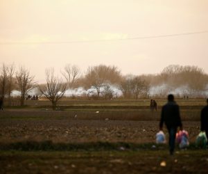 Migrants walk near Turkey's Pazarkule border crossing with Greece's Kastanies, near Edirne Migrants walk past rising clouds of tear gas near Turkey's Pazarkule border crossing with Greece's Kastanies, near Edirne, Turkey, March 7, 2020. REUTERS/Huseyin Aldemir HUSEYIN ALDEMIR