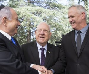 epa08329017 (FILE) -  Israeli Prime Minister Benjamin Netanyahu (L), Israeli President Reuven Rivlin (C) and Benny Gantz, former Israeli Army Chief of Staff and chairman of the Blue and White Israeli centrist political alliance (R) join hands as they attend a memorial service for late Israeli president Shimon Peres at Mount Herzl, Israel's national cemetery, in Jerusalem, 19 September 2019. Media reports that Netanyahu has cracked down on advance talks about going to unity government following the state crisis  dealing with the spread of the SARS-CoV-2 coronavirus.  EPA/ABIR SULTAN
