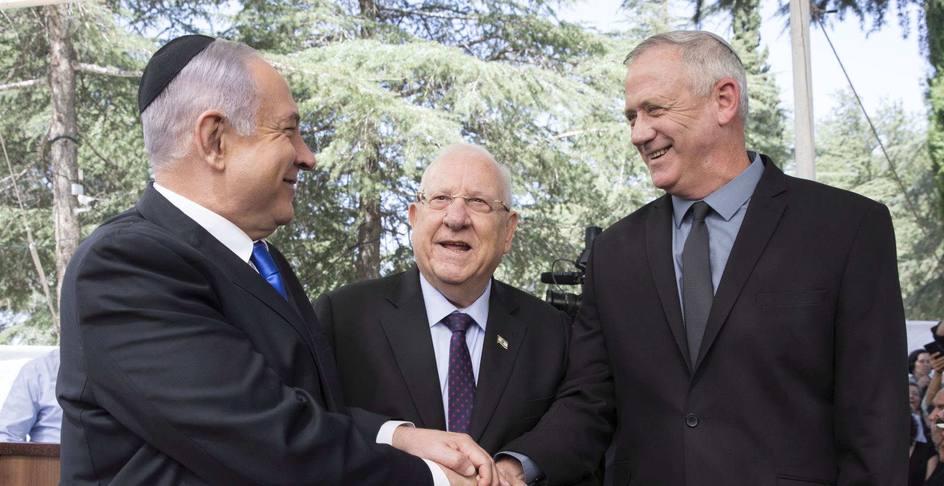 epa08329017 (FILE) -  Israeli Prime Minister Benjamin Netanyahu (L), Israeli President Reuven Rivlin (C) and Benny Gantz, former Israeli Army Chief of Staff and chairman of the Blue and White Israeli centrist political alliance (R) join hands as they attend a memorial service for late Israeli president Shimon Peres at Mount Herzl, Israel's national cemetery, in Jerusalem, 19 September 2019. Media reports that Netanyahu has cracked down on advance talks about going to unity government following the state crisis  dealing with the spread of the SARS-CoV-2 coronavirus.  EPA/ABIR SULTAN