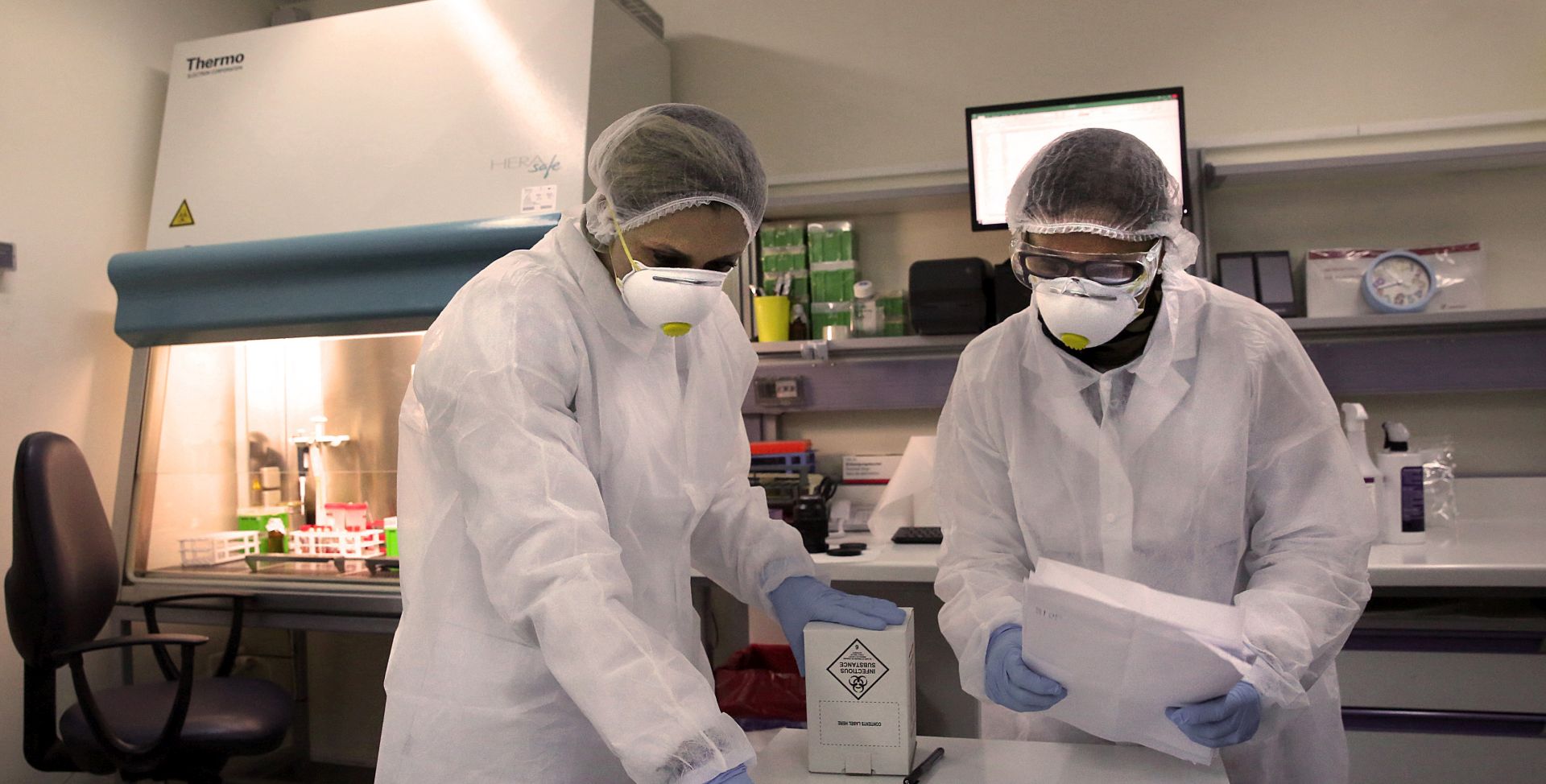 epa08347310 Microbiologists at the Hellenic Pasteur Institute work in the institute's 3rd-level biosafety laboratory, which performs tests to detect the presence of the novel SARS-CoV-2 coronavirus that causes the pandemic COVID-19 disease, in Athens, Greece, 06 April 2020 (issued 07 April 2020).  EPA/ORESTIS PANAGIOTOU