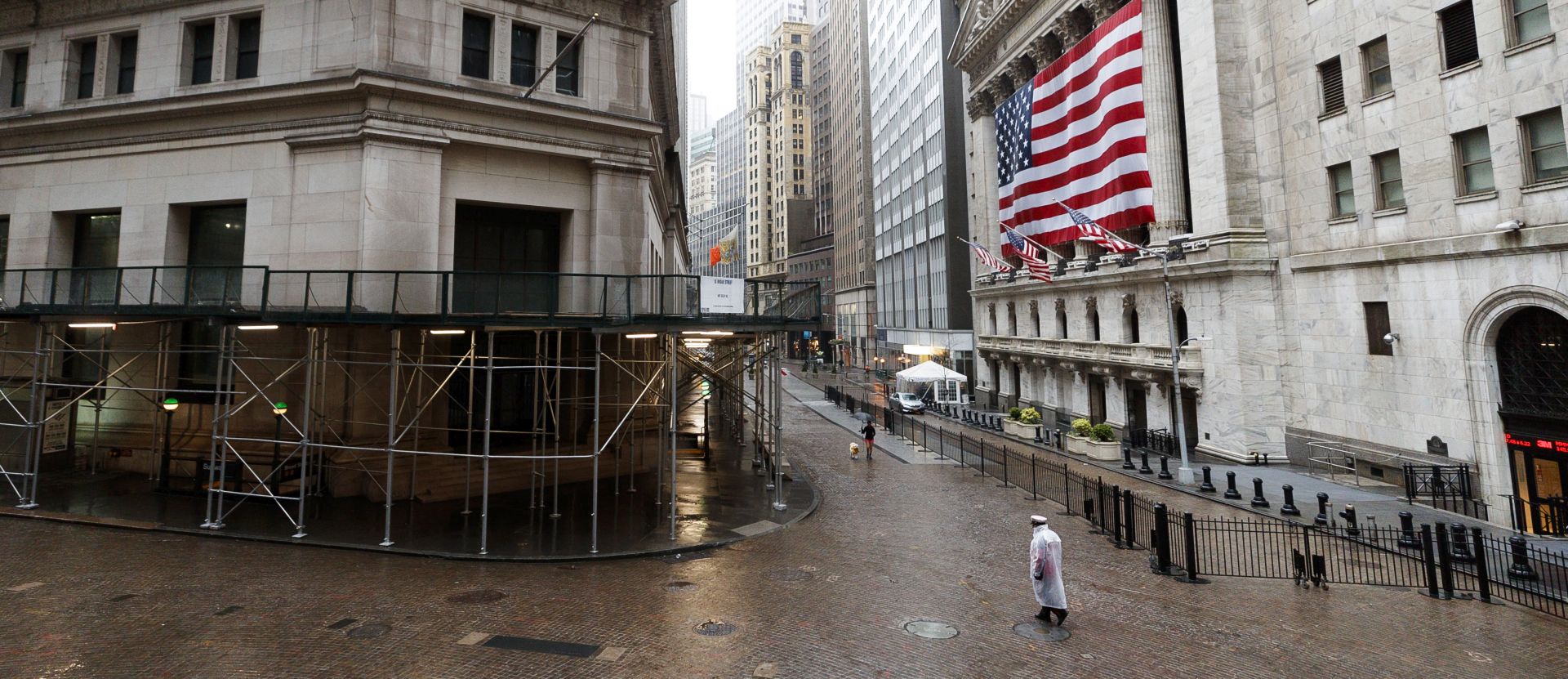 epa08361140 People walk along a quiet Wall Street past the New York Stock Exchange in New York, New York, USA, 13 April 2020. Restrictions requiring the shut down of all non-essential businesses are currently in place around the United States to stop the spread of the highly-contagious coronavirus. These restrictions are having massive economic implications and some local and federal politicians are begining to suggest plans for lifting some rules in an effort to get parts of the economy going again; many health officials are worried this will lead to another spike in COVID-19 cases.  EPA/JUSTIN LANE