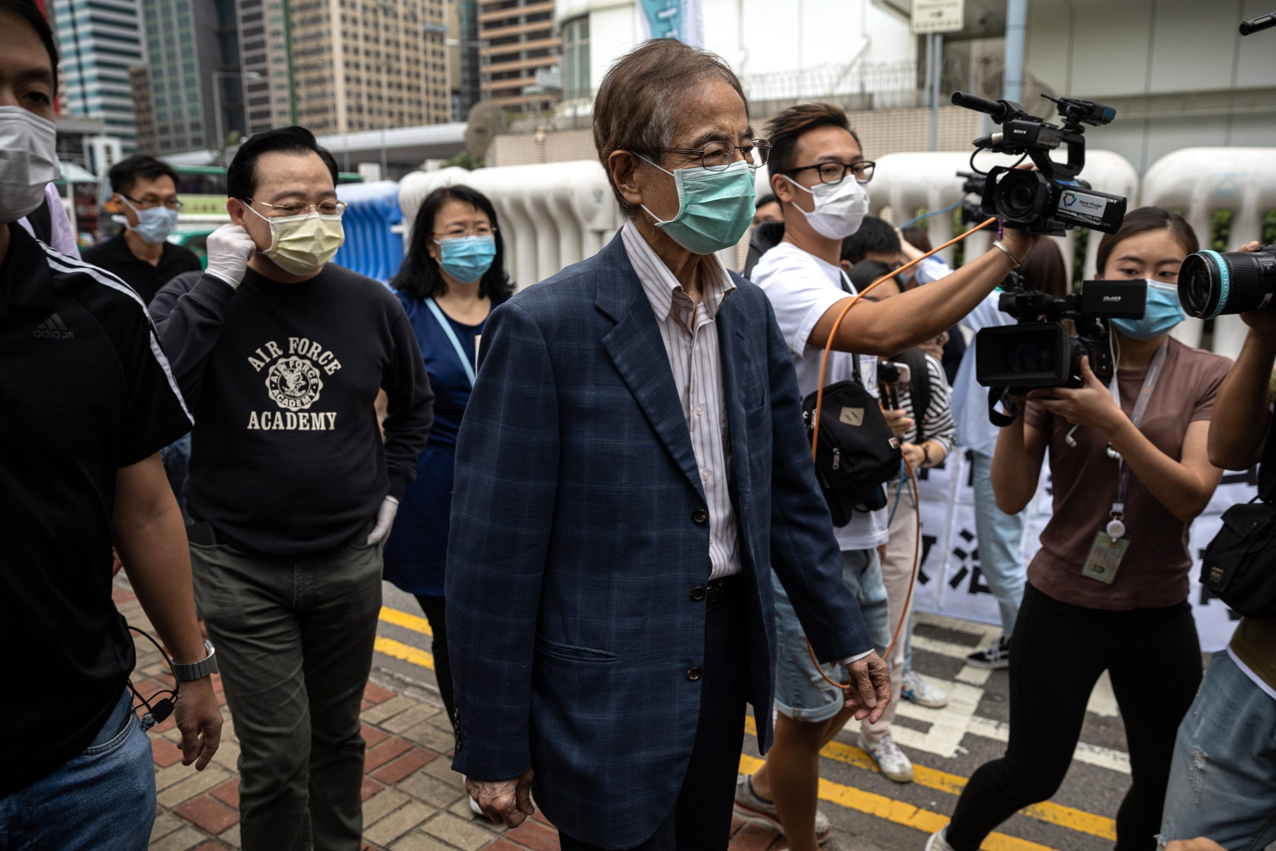 epa08370341 Veteran pro-democracy figure and former lawmaker Martin Lee (C) is chased by journalists after walking out of Central Police Station in Hong Kong, China, 18 April 2020.  Police arrested 14 high-profile pro-democracy figures in connection with several anti-government protests of 2019, including media tycoon Jimmy Lai and veteran pro-democracy figure and former lawmaker Martin Lee.  EPA/JEROME FAVRE