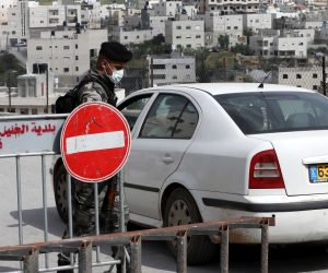 epa08371882 Palestinian security personnel opens a road at a checkpoint at an entrance to the West Bank city of Hebron, 19 April 2020. Palestinian authorities banned movement of people between cities to help stop the spread of the coronavirus which causes the Covid-19 disease.  EPA/ABED AL HASHLAMOUN