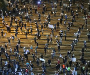 epa08372029 Israelis turn on their mobile phone lights as they protest against government corruption and for democracy at Rabin square in Tel Aviv, Israel, 15 April 2020. Reports state that around 2,000 people took part in the demonstration keeping two meters distance from each other in order to prevent the spread of the SARS-CoV-2 coronavirus which causes he Covid-19 disease.  EPA/ABIR SULTAN