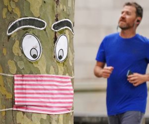 epaselect epa08384674 A man runs past a tree with a face mask and eyes stapled to it in Melbourne, Australia, 26 April 2020. Authorities have said social distancing and isolation measures could still remain in place for the next six months.  A shutdown of non-essential services is in effect Australia wide in a bid to slow the spread of the coronavirus (COVID-19) disease.  EPA/SCOTT BARBOUR NO ARCHIVING AUSTRALIA AND NEW ZEALAND OUT