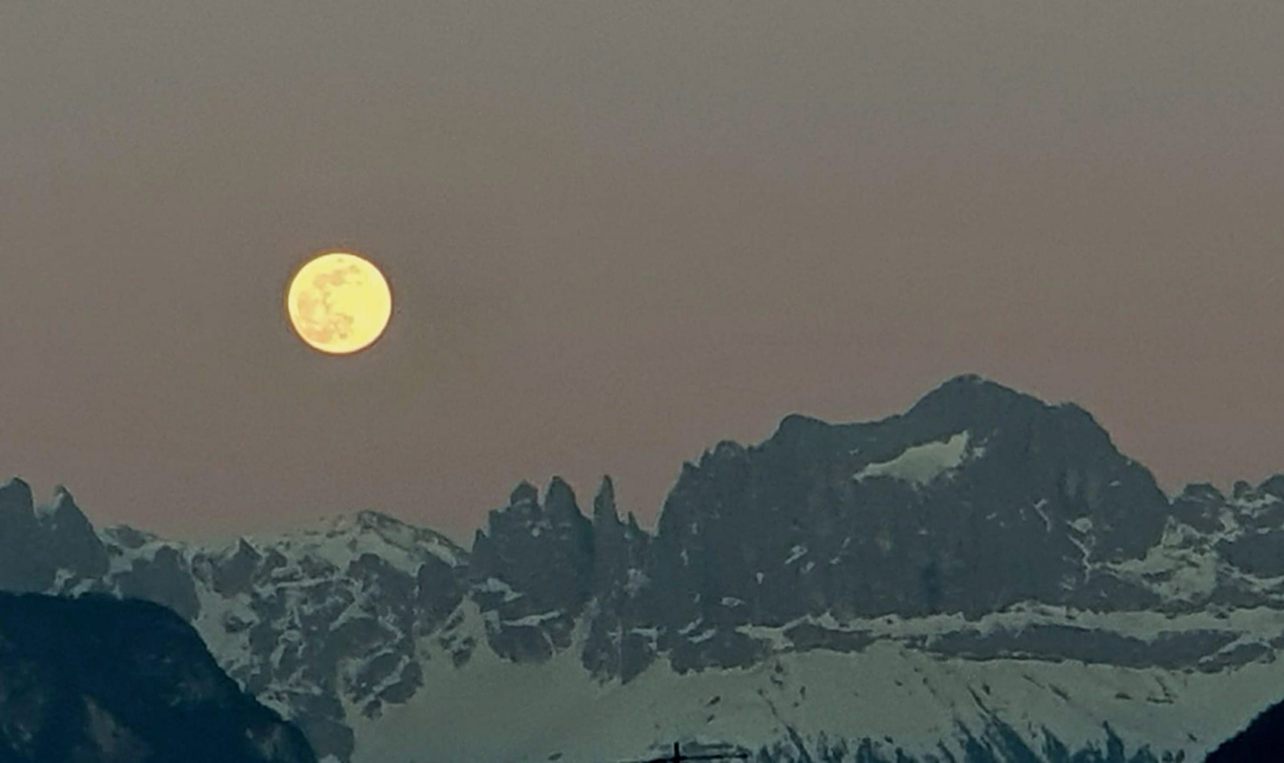 epa08349030 The most spectacular supermoon of 2020 called Super Pink Moon shines over the Catinaccio mountain, near Bozen, northern Italy, 07 April 2020. The full Moon is in fact closer than usual and appears a little larger and 15 percent brighter. It is the third, after those of the previous two months, but it's even more super because it's even closer.  EPA/GIULIANO RIGHI
