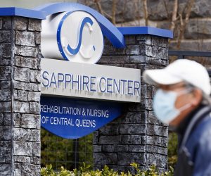 epa08369814 A man walks past the Sapphire Center for Rehabilitation and Nursing of Central Queens in Queens, New York, USA, on 17 April 2020. Twenty-nine residents at the nursing home have been confirmed to have died between 01 March and 15 April, but according to news reports, as many as 60 residents may have died as a result of the coronavirus at the 227-bed facility.  EPA/JUSTIN LANE