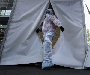 epa08385697 A medical specialist wearing a protective suit waits for patients  on SARS-CoV-2 coronavirus test in mobile laboratory at the deserted business center Moscow City in Moscow, Russia, 26 April 2020. Russian President Vladimir Putin extended the current nationwide lockdown with stay-at-home orders until the end of April in a bid to slow down the spread of the pandemic COVID-19 disease caused by the SARS-CoV-2 coronavirus.  EPA/MAXIM SHIPENKOV