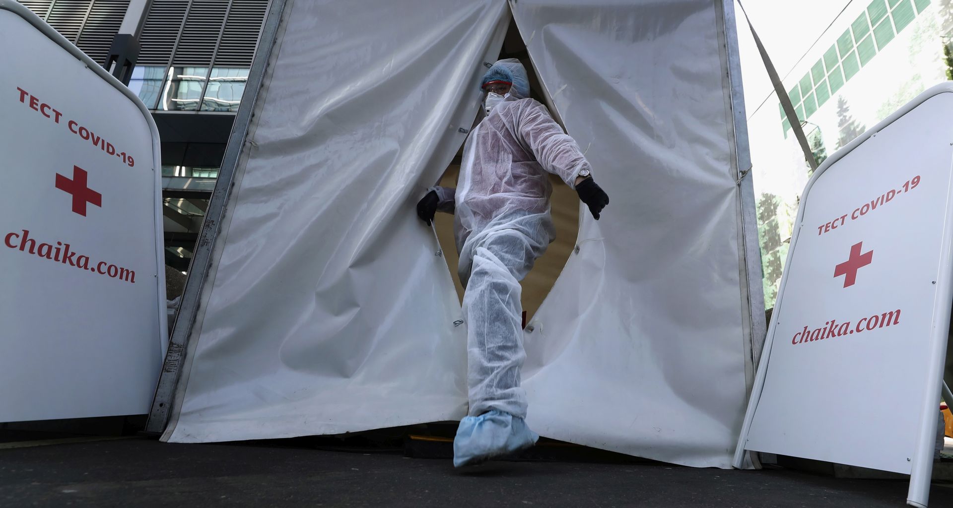 epa08385697 A medical specialist wearing a protective suit waits for patients  on SARS-CoV-2 coronavirus test in mobile laboratory at the deserted business center Moscow City in Moscow, Russia, 26 April 2020. Russian President Vladimir Putin extended the current nationwide lockdown with stay-at-home orders until the end of April in a bid to slow down the spread of the pandemic COVID-19 disease caused by the SARS-CoV-2 coronavirus.  EPA/MAXIM SHIPENKOV
