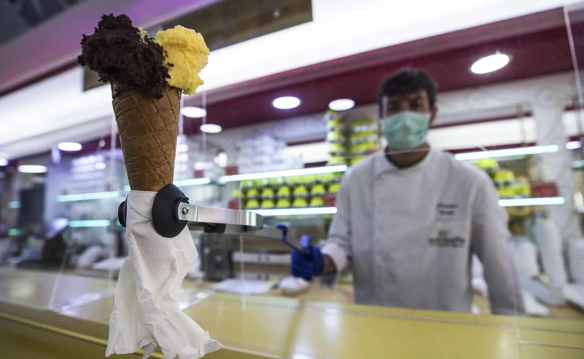 epaselect epa08392865 An ice cream vendor wears a protective mask while working in an ice cream shop in the center of Rome, Italy, 30 April 2020. Italy was still under a emergency lockdown due to Covid-19 pandemic.  EPA/ANGELO CARCONI