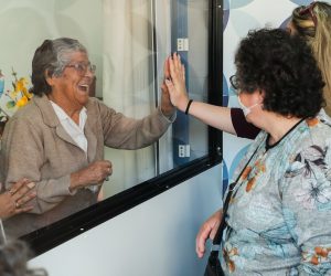 epa08398779 Isabel Barreto, a resident of the União Mutualista Nossa Senhora da Conceição (Mutualist Union Our Lady of the Conception) retirement home in Montijo, during the first visit of her relatives after two months without being able to do so, in Montijo, Portugal, 03 May 2020. In order for family members to be able to visit the residents of the home, the Box das Emoções (lit.: Box of Emotions)was created, a small room that meets all the safety standards required by the contingency plan in force for the covid-19, equipped with microphones and that allows visits without any of the residents of the home going outside and without any of the family members having direct contact with the facilities.  EPA/MIGUEL A. LOPES