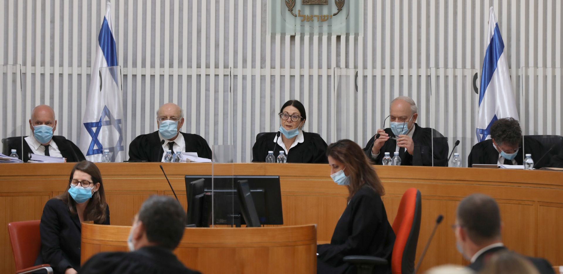 epa08400252 A panel of judges of the Israeli Supreme Court wearing face masks adresses a crucial discussion on a petition asking whether Prime Minister Benjamin Netanyahu can form a government legally and publicly when indictments are filed against him on a charges of fraud, bribery and breach of trust, at the  Israeli Supreme Court in Jerusalem, Israel, 04 May 2020.  EPA/ABIR SULTAN / POOL