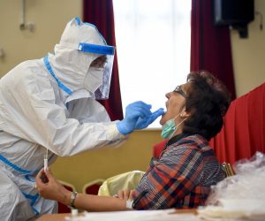 epa08400781 A medical professional wearing a protective suit takes a sample for a coronavirus test at a temporary testing station operated by the University of Debrecen Clinical Center in Berettyoujfalu, Hungary, 04 May, 2020. Four Hungarian medical training schools have begun the screening of some 18 thousand people as a representative statistical sample to get exact figures concerning the spread of the coronavirus in Hungary.  EPA/Zsolt Czegledi HUNGARY OUT