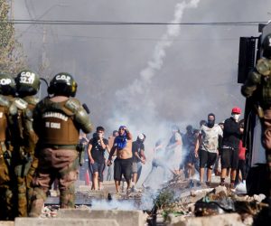 epa08431062 People clash with police during a protest for lack of food, during the State of Constitutional Exception of Catastrophe decreed by Chilean President, to prevent the spread of the Coronavirus, in Santiago, Chile 18 May 2020. Around a hundred residents of El Bosque, a town on the outskirts of Santiago, protested this Monday to denounce the lack of food and poverty they suffer due to the quarantine decreed by the Government to try to contain the coronavirus pandemic SARS-CoV-2.  EPA/SEBASTIAN SILVA