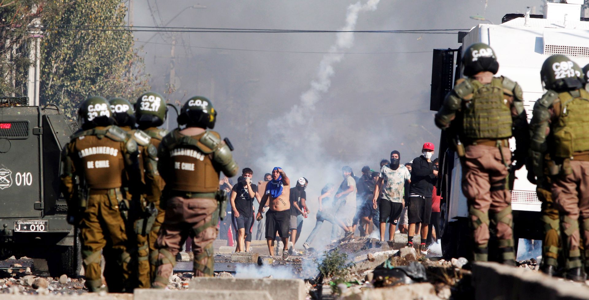 epa08431062 People clash with police during a protest for lack of food, during the State of Constitutional Exception of Catastrophe decreed by Chilean President, to prevent the spread of the Coronavirus, in Santiago, Chile 18 May 2020. Around a hundred residents of El Bosque, a town on the outskirts of Santiago, protested this Monday to denounce the lack of food and poverty they suffer due to the quarantine decreed by the Government to try to contain the coronavirus pandemic SARS-CoV-2.  EPA/SEBASTIAN SILVA