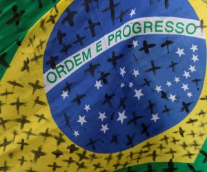 epa08434295 Detail of a Brazilian flag with black crosses painted to honor and remember the victims of covid-19 in that country, during a protest against the President of Brazil, Jair Bolsonaro, at the Planalto Palace in Brasilia, Brazil, 20 May 2020. Convened by the members of the popular committee 'Bolsonaro Out', dozens of people participated in the demonstration that rejected Bolsonaro's statements and actions during the handling of the coronavirus crisis, which left more than 17,000 deaths in the South American country.  EPA/JOEDSON ALVES