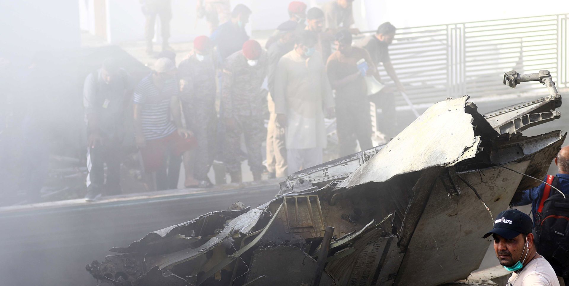 epa08437580 Rescue workers search for the bodies or survivors amid wreckage of the passenger plane of state run Pakistan International Airlines, after it crashed on a residential colony, in Karachi, Pakistan, 22 May 2020. A Pakistan International Airlines passenger flight with over 100 people on board crashed on 22 May as it was about to land near a residential area close to the airport in the port city of Karachi, a civil aviation official said.  EPA/SHAHZAIB AKBER