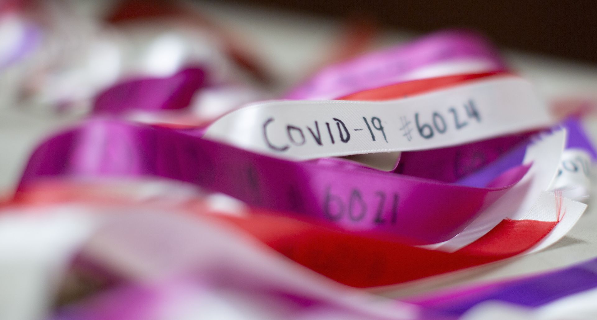 epa08438132 Ribbons, numbered up to and over 6000, are affixed to a line as part of a memorial to be hung on the exterior of the Grant African Methodist Episcopalian Church in Boston, Massachusetts, USA 22 May 2020. In an effort to show compassion and a memorial for the victims of the coronavirus, church members have been hanging ribbons to represent each of the dead each week.  EPA/CJ GUNTHER