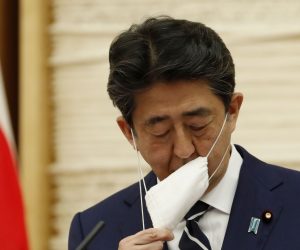 epa08442569 Japan's Prime Minister Shinzo Abe removes his mask as he arrives at a news conference in Tokyo, Japan, 25 May 2020. According to media reports, Abe lifted the state of emergency in the country after a dramatic drop in coronavirus cases.  EPA/KIM KYUNG-HOON / POOL