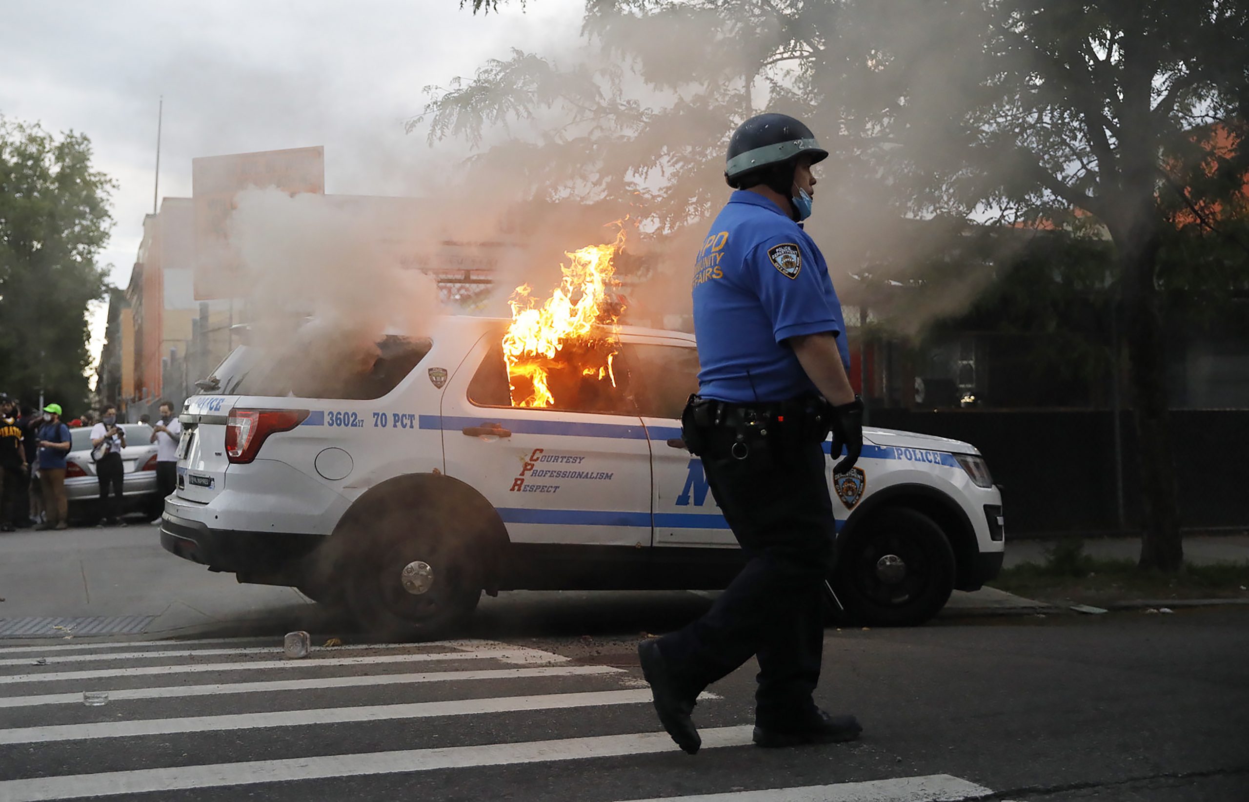 epa08455208 A New York City Police Department vehicle burns after being set alight by protesters as they demostrate about the arrest of George Floyd, who later died in police custody, in Brooklyn, New York, USA, 30 May 2020. A bystander's video posted online on 25 May, appeared to show George Floyd, 46, pleading with arresting officers that he couldn't breathe as an officer knelt on his neck. The unarmed black man later died in police custody.  EPA/KEVIN HAGEN