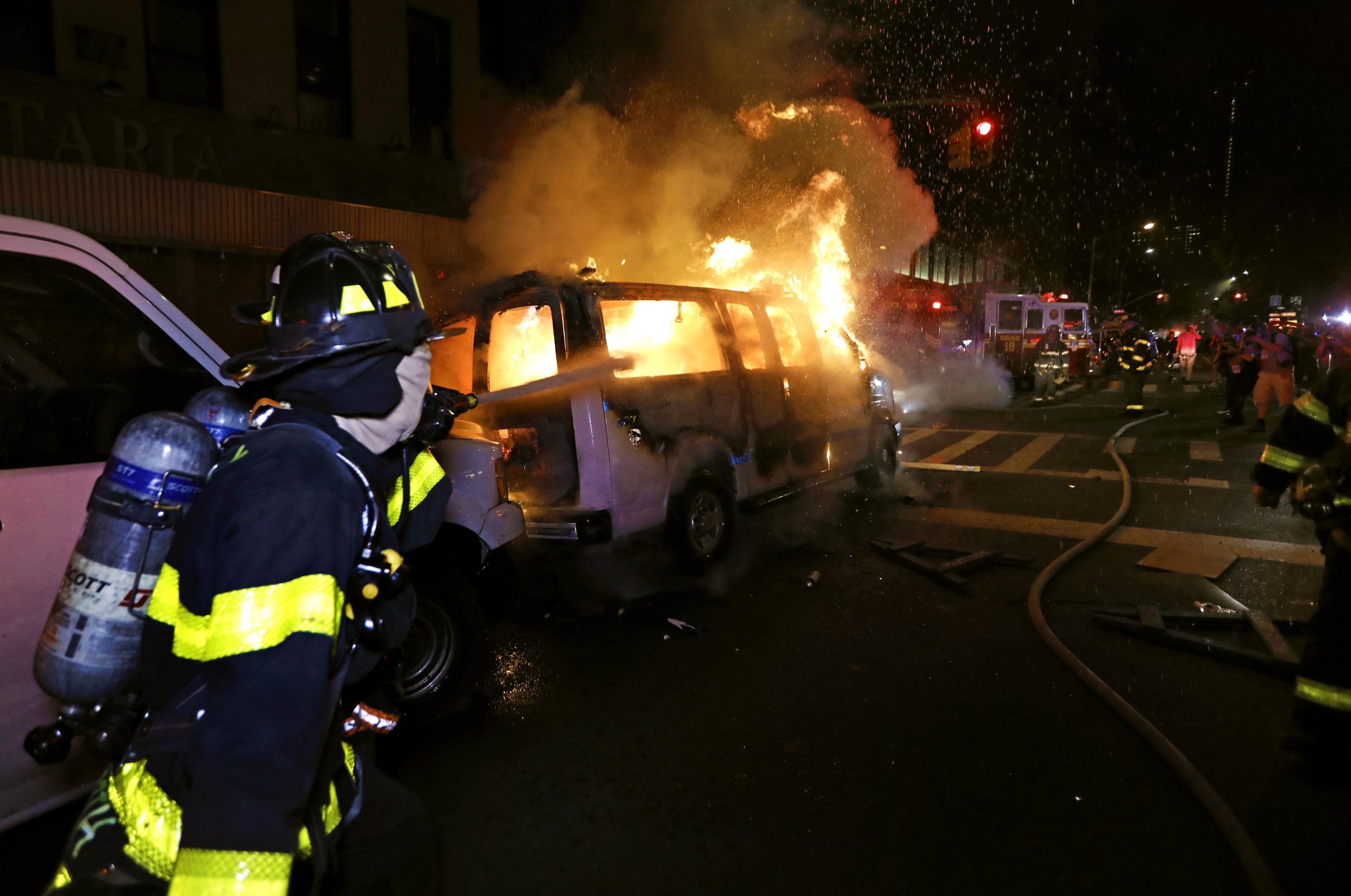 epa08455395 New York City firefighters spray water on a police van set ablaze by protesters during protests over the Minneapolis arrest of George Floyd, who later died in police custody, in Harlem, New York, USA, 30 May 2020. A bystander's video posted online on 25 May, appeared to show George Floyd, 46, pleading with arresting officers that he couldn't breathe as an officer knelt on his neck. The unarmed Black man later died in police custody. On 29 May, Derek Chauvin, the police officer in the center of the incident has been taken into costody and charged with murder in the Floyd arrest.  EPA/PETER FOLEY