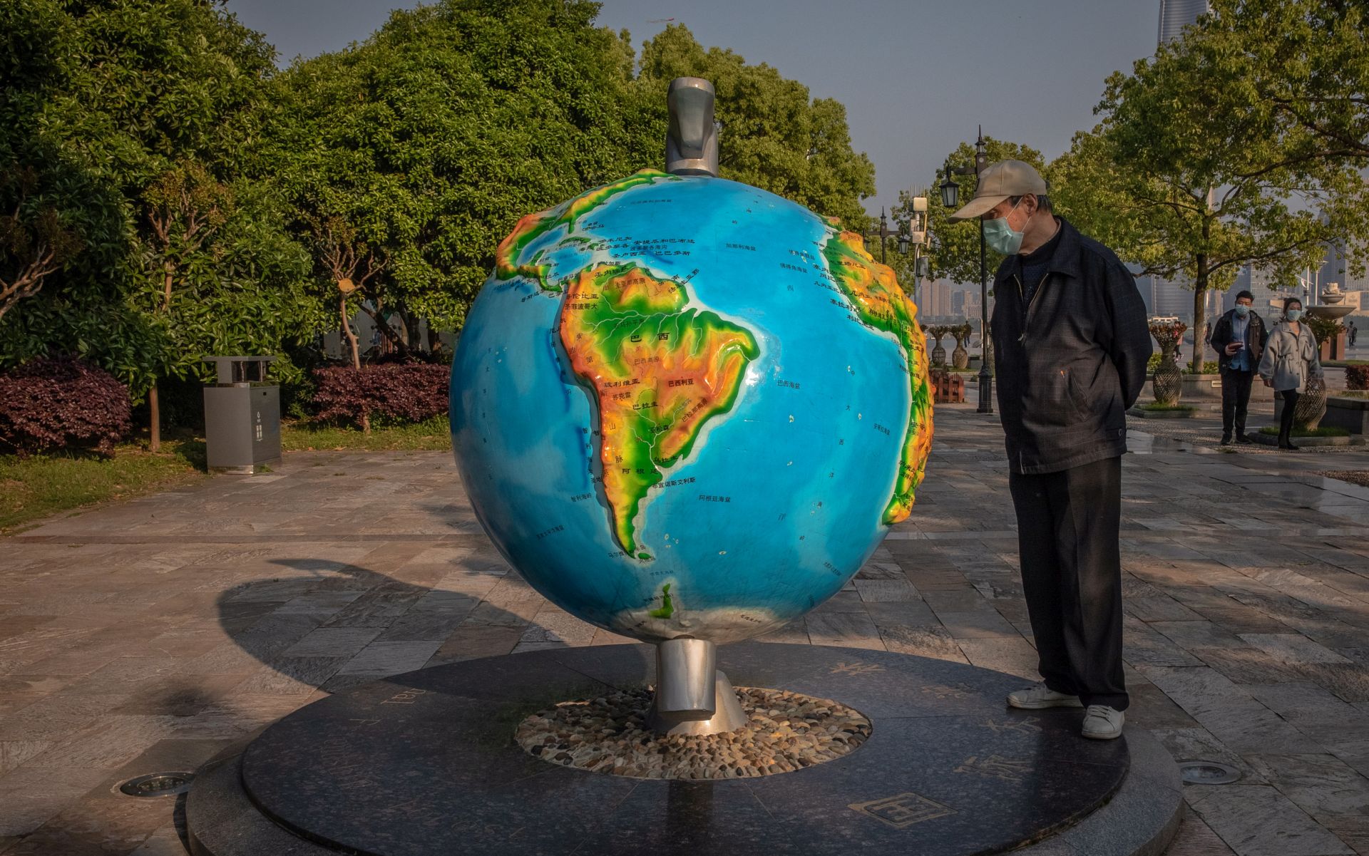 epa08416275 A man with face mask looks at a globe depicting turquoise colored oceans in the riverside park along the Yangtze River in Wuhan, China, 12 April 2020 (reissued 12 May 2020). Turquoise, originally the French word for 'Turkish' referring to the country of origin of the precious blue-green colored mineral gem, is the color that fits in between green and blue and covers a wide range of 'shades' from the greenish turquoise of sea waters to the blueish turquoise of summer skies. In color psychology it is associated with creating emotional balance and stability.  EPA/ROMAN PILIPEY  ATTENTION: This Image is part of a PHOTO SET