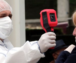 epa08430197 A health worker measures the temperature of a woman outside a hospital in Sarajevo, Bosnia and Herzegovina, 18 May 2020. Countries around the world are taking increased measures to stem the widespread of the SARS-CoV-2 coronavirus which causes the Covid-19 disease.  EPA/FEHIM DEMIR