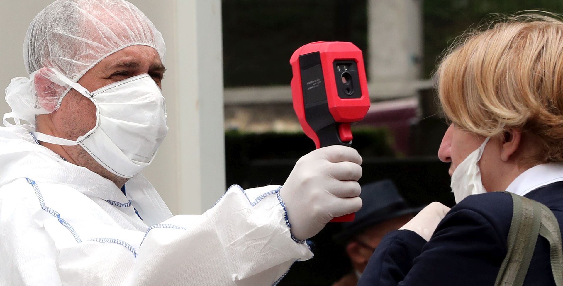 epa08430197 A health worker measures the temperature of a woman outside a hospital in Sarajevo, Bosnia and Herzegovina, 18 May 2020. Countries around the world are taking increased measures to stem the widespread of the SARS-CoV-2 coronavirus which causes the Covid-19 disease.  EPA/FEHIM DEMIR