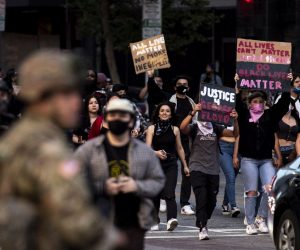 epa08457170 Demonstrators react as they pass National Guard members during protests over the death of George Floyd, who died in police custody, at Pershing Square in Los Angeles, California, USA, 31 May 2020. A bystander's video posted online on 25 May appeared to show George Floyd, 46, pleading with arresting officers that he couldn't breathe as an officer knelt on his neck, in Minnesota. The unarmed black man later died in police custody.  EPA/ETIENNE LAURENT