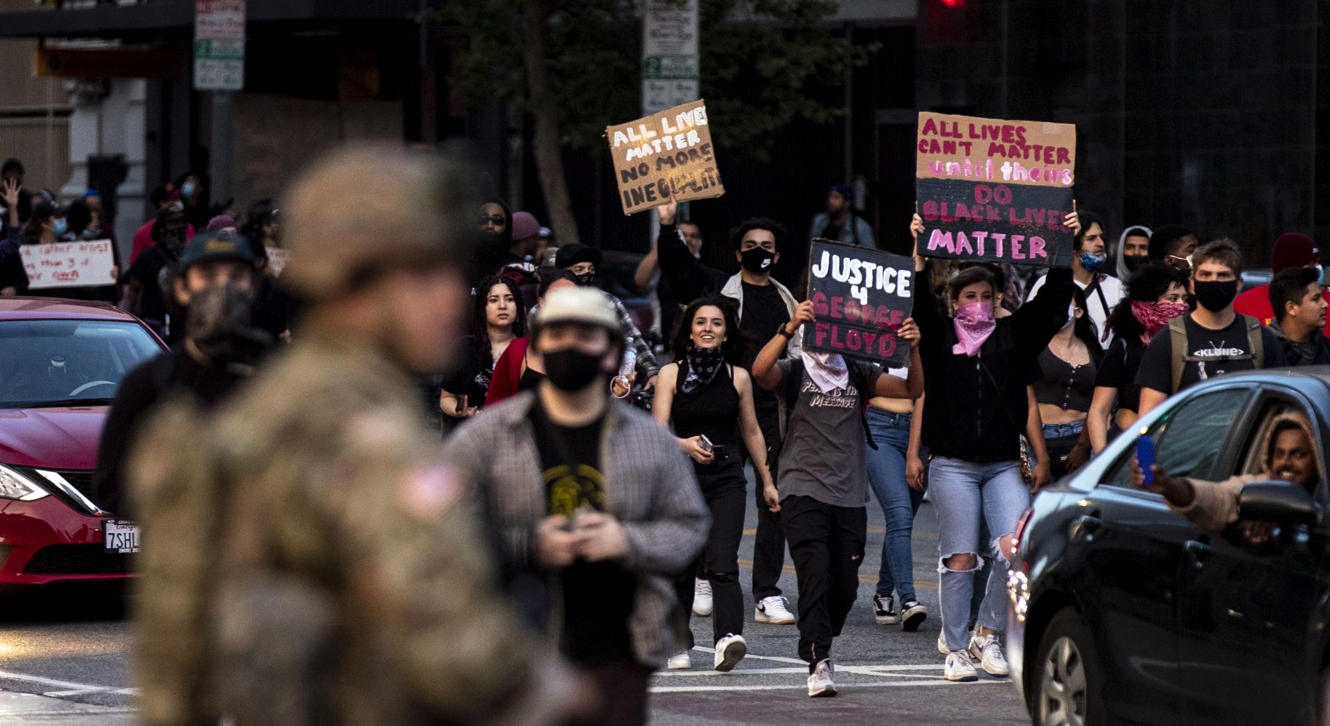 epa08457170 Demonstrators react as they pass National Guard members during protests over the death of George Floyd, who died in police custody, at Pershing Square in Los Angeles, California, USA, 31 May 2020. A bystander's video posted online on 25 May appeared to show George Floyd, 46, pleading with arresting officers that he couldn't breathe as an officer knelt on his neck, in Minnesota. The unarmed black man later died in police custody.  EPA/ETIENNE LAURENT
