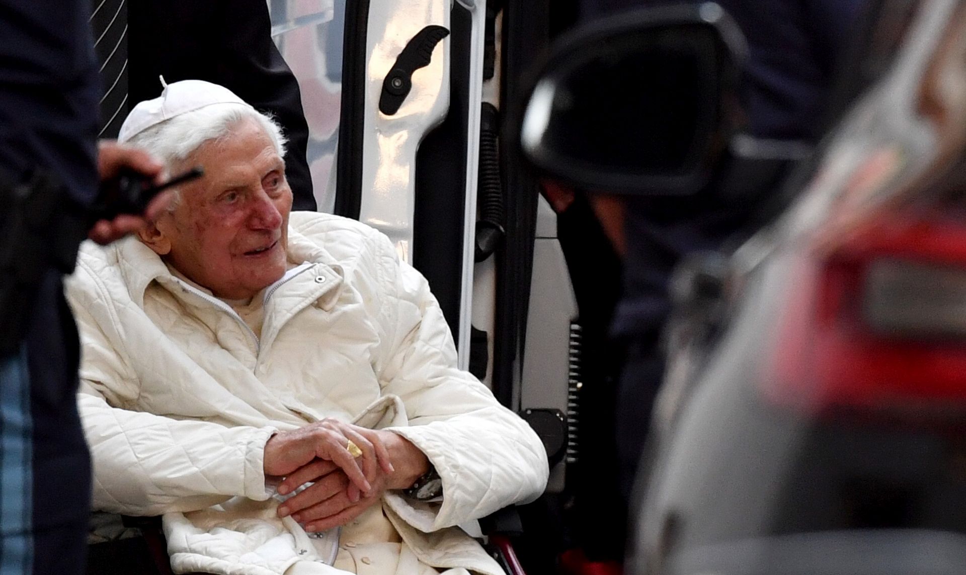 epa08494342 Pope Emeritus Benedict XVI (C) sits in a wheelchair as he leaves the house of his brother Georg Ratzinger, after a visit in Regensburg, Germany, 18 June 2020. According to a German Bishops' Conference press release, Pope Emeritus Benedict XVI is on an unannounced visit to Germany to see his brother Georg Ratzinger, whose health has reportedly deteriorated.  EPA/PHILIPP GUELLAND