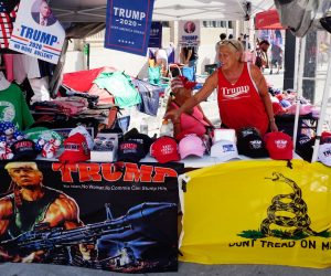 epaselect epa08499190 A vendor sells Trump campaingn items as crowds of protesters and supporters of US Presdient Donald J. Trump interact outside the fencing surrounding the Bank of Oklahoma Center hours before Trump holds a rally in Tulsa, Oklahoma, USA, 20 June 2020. The campaign rally is the first since the COVID-19 pandemic locked most of the country down in March 2020.  EPA/YOUNG G. KIM