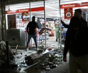 dpatop - 21 June 2020, Baden-Wuerttemberg, Stuttgart: People stand in front of a looted shop in Marien street after several people rioted in downtown Stuttgart during night. Photo: Julian Rettig/dpa