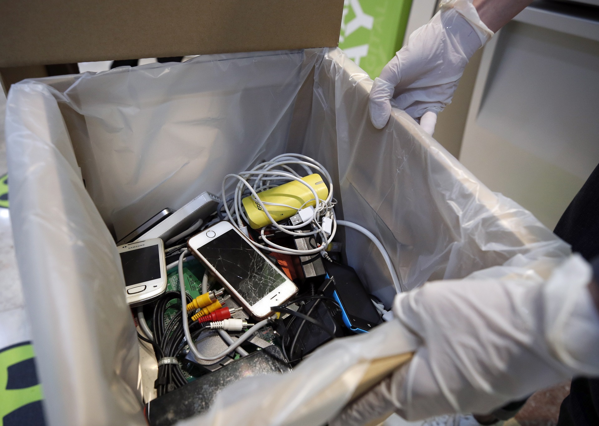 epa08484356 A staff member displays electronic waste at an Advanced Info Service (AIS) shop in Bangkok, Thailand, 05 June 2020 (issued 14 June 2020). Thailand's AIS, a mobile phone operator company, launched its electronic wastes disposal campaign by setting up recycled bins across the country and encouraging people to drop off their electronic waste such as broken mobile phones, earphones, adaptors, old tablets, batteries and other e-waste. Thailand has exceeded 400,000 tons of hazardous waste from electronic appliances.  EPA/RUNGROJ YONGRIT