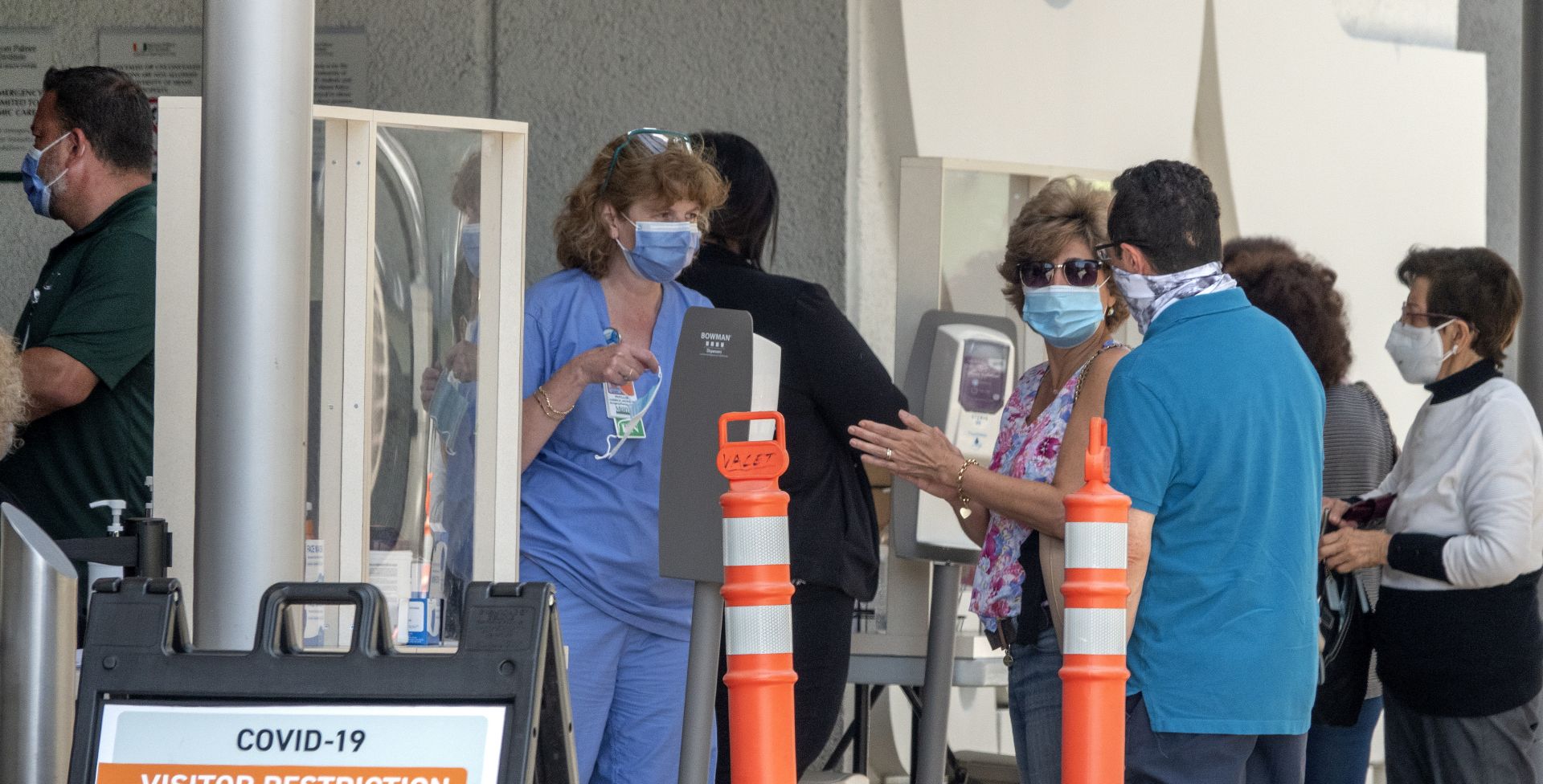epa08502356 People wearing masks wait to enter to the Jackson Memorial Hospital in Miami, Florida, USA, 22 June 2020. The state of Florida is now up to 100,217 total confirmed cases and 3,173 deaths associated with COVID-19, according to the latest data released by the health department and it becomes the seventh state to pass 100,000 coronavirus cases, after New York, California, New Jersey, Illinois, Texas and Massachusetts.  EPA/CRISTOBAL HERRERA