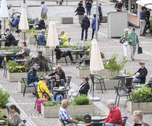epa08520262 People sit on the Super Terrace that has been opened at Senate Square in Helsinki, Finland, 01 July 2020. It provides seating for 480 people and a number of pop-up restaurants to be introduced to the square as a means of allowing safer dining in the age of COVID-19. The terrace is open until the end of August 2020.  EPA/KIMMO BRANDT