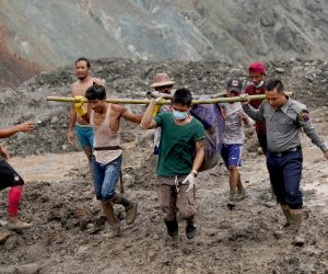 epa08522654 Police and volunteers carry the body of a victim after a landslide at a jade mining site in Hpakant, Kachin State, Myanmar, 02 July 2020. According to media reports, search and rescue efforts are ongoing after a landslide at a jade mining site was triggered by heavy rain. At least 126 bodies have been found, media added.  EPA/ZAW MOE HTET