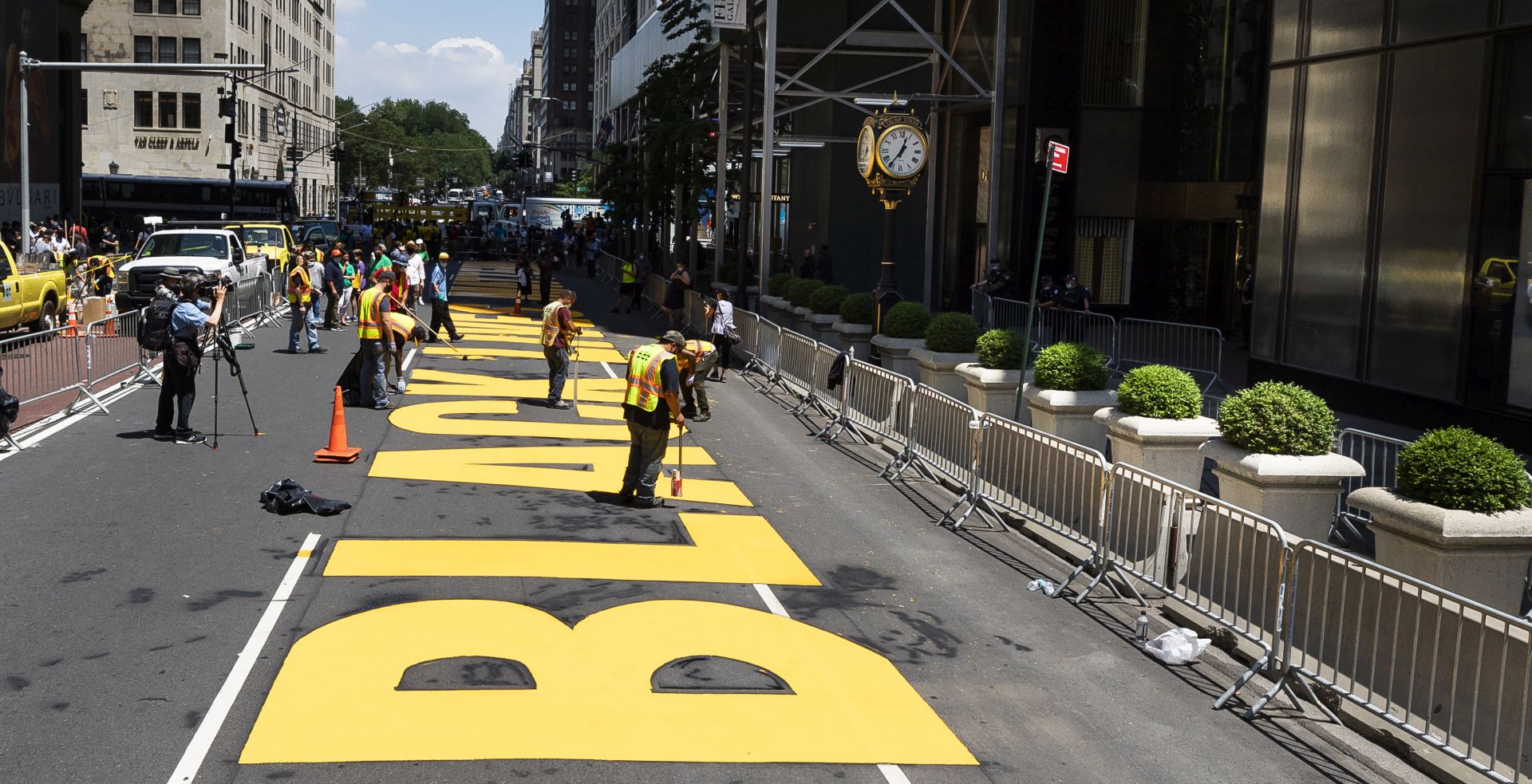 epa08537121 Workers put the finishing touches on lettering reading 'Black Lives Matter' on Fifth Avenue in from of Trump Tower (R) in New York, New York, USA, 09 July 2020. New York City Mayor Bill de Blasio approved the public art project as a way to directly counter President Donald Trump’s dismissal of the Black Lives Matter movement.  EPA/JUSTIN LANE