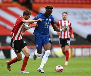epa08540709 Chris Basham of Sheffield (L) in action against Tammy Abraham of Chelsea (C) during the English Premier League match between Sheffield United and Chelsea in Sheffield, Britain, 11 July 2020.  EPA/Shaun Botterill/NMC/Pool EDITORIAL USE ONLY. No use with unauthorized audio, video, data, fixture lists, club/league logos or 'live' services. Online in-match use limited to 120 images, no video emulation. No use in betting, games or single club/league/player publications.