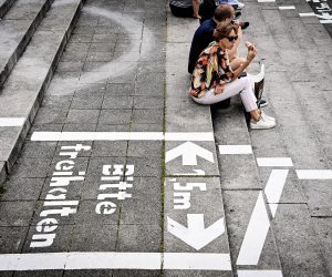 epa08548056 People sit on the steps of the Burgplatz with painted lines for social distance at the Rhine promenade in Duesseldorf, Germany, 15 July 2020. As a precautionary measure, the city of Duesseldorf is preparing for further increases, after 16.6 people per 100,000 inhabitants have become infected with the coronavirus in Duesseldorf in the past seven days.  EPA/SASCHA STEINBACH