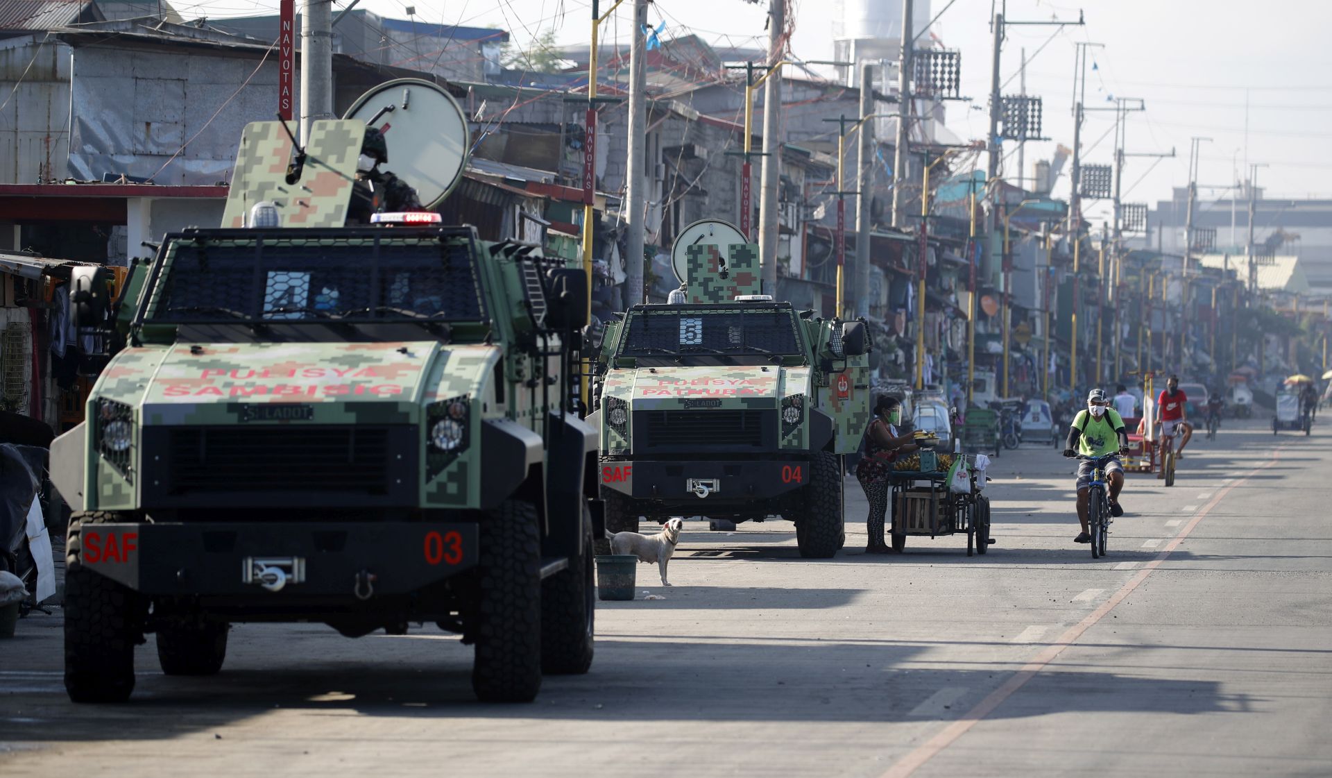 epa08548823 Filipino police officers on armored personnel carriers conduct a patrol during a lockdown in Navotas City, Philippines, 16 July 2020. According to reports, Navotas City will go back into a two week lockdown starting on 16 July, to contain the surge of coronavirus infections.  EPA/FRANCIS R. MALASIG