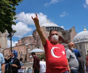 epa08551728 A Turkish nationalist flashes a grey wolf sign which is the symbol of Turkish Nationalists in front of the Hagia Sophia as Turkish people continue to celebrate Turkey's decision that the 1,500 year old UNESCO World Heritage site Hagia Sophia can be converted into a mosque, in Istanbul, Turkey, 17 July 2020. Turkey's highest administration court on 10 July 2020 ruled that the museum that was once a mosque built in a Cathedral can be turned into a mosque again by annulling its status as museum. Hagia Sophia will open on 24 July 2020 as a mosque and Turkish President Recep Tayyip Erdogan will attend first Friday pray.  EPA/SEDAT SUNA