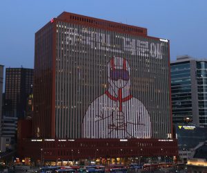 epa08534358 A video featuring an image of a person in protective clothing giving a thumbs-up is displayed on the wall of a building in central Seoul, south Korea, 08 July 2020, as part of a campaign to show appreciation to medical workers and health officials for their efforts in fighting the coronavirus pandemic.  EPA/YONHAP SOUTH KOREA OUT