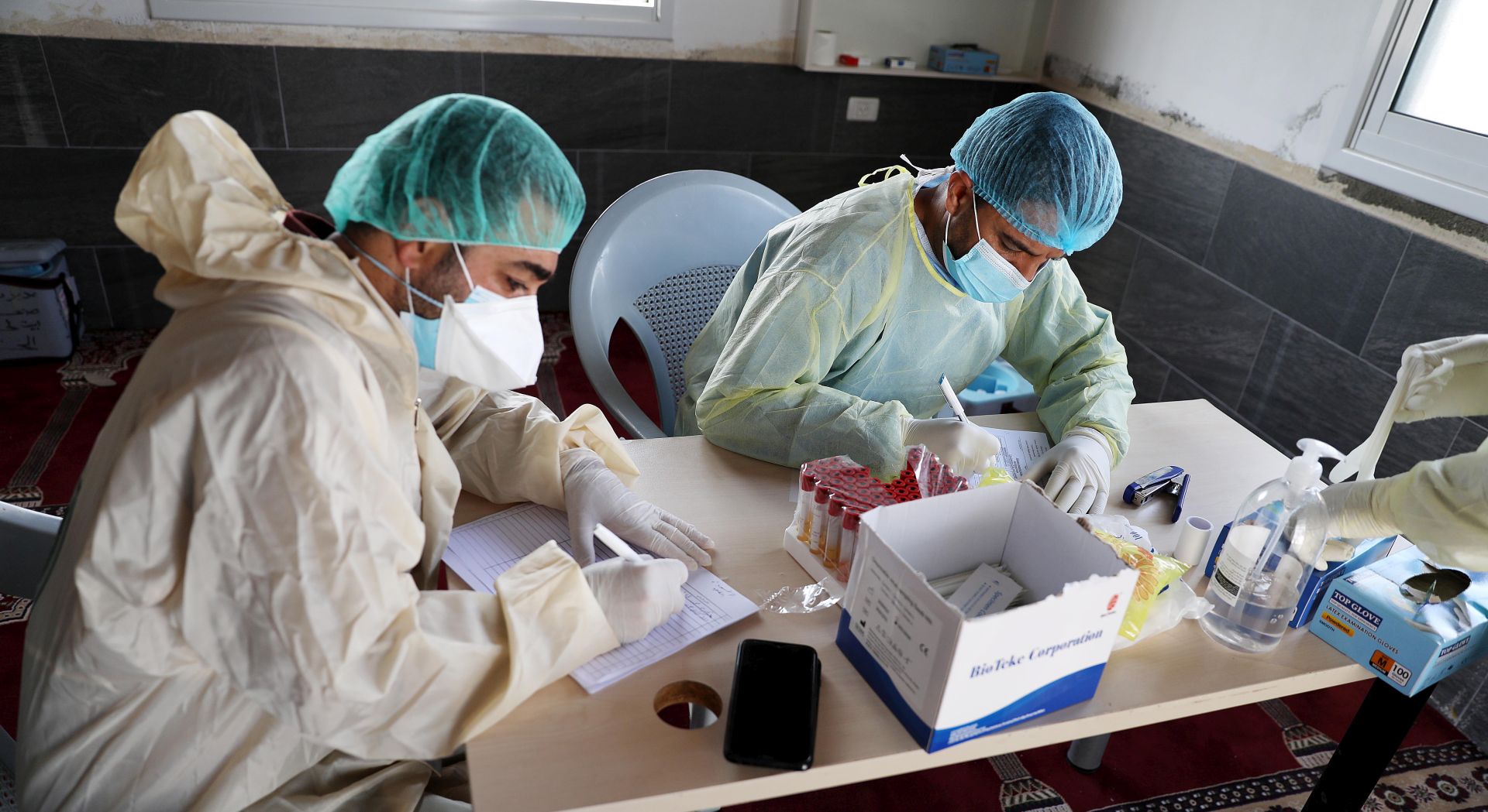 epa08572163 Palestinian medical staff collecting swab samples for COVID-19 testing in the COVID-19 section of Dhahria hospital in the West Bank city of Dhahria, near Hebron, 29 July 2020.  EPA/ABED AL HASHLAMOUN