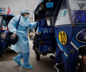 epa08577442 A nurse from the Cerro El Agustino medical post gets on the motorcycle taxi that will take her to the highlands to vaccinate the most vulnerable people against the flu and pneumonia, in Lima, Peru, 31 July 2020. Without having yet defeated COVID-19, Peru entered the winter, the favorite season of the flu and pneumonia, two old acquaintances who are fought on board the humble but effective motorcycle taxis, the only transport capable of carrying the vaccines to the top of the most inaccessible hills.  EPA/Paolo Aguilar  ATTENTION: This Image is part of a PHOTO SET
