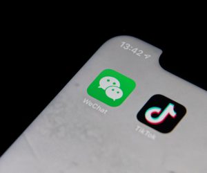 epa08588968 A posed photo shows the icons of Chinese internet media apps WeChat (L) and TikTok (R) being displayed on a phone, in Beijing, China, 07 August 2020. According to media reports, US President Donald Trump has issued an executive order to ban US transactions with Chinese companies Tencent and ByteDance.  EPA/ROMAN PILIPEY