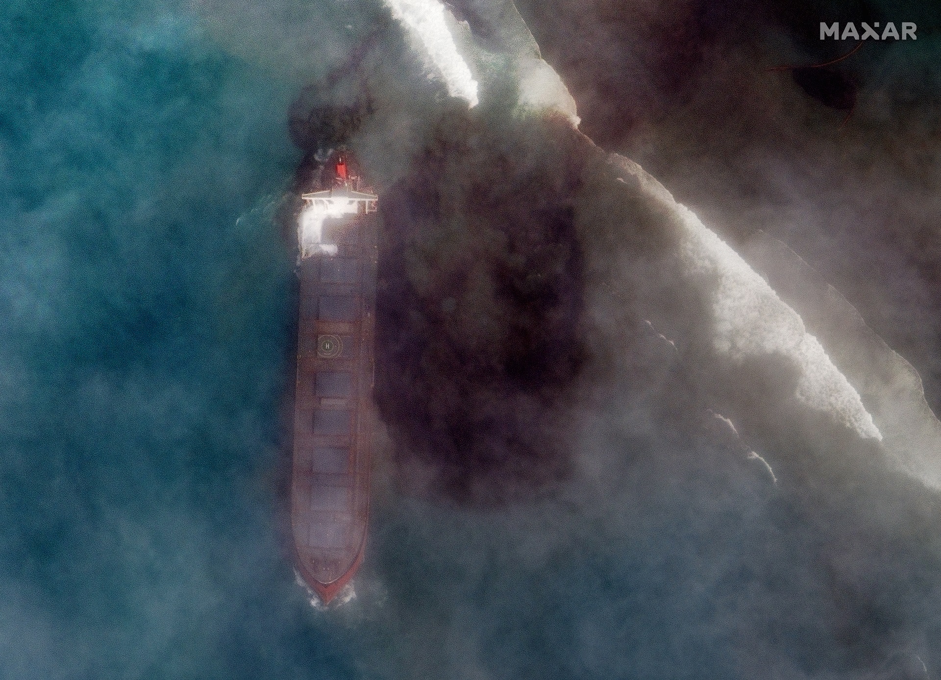 epa08590349 A handout satellite image made available by MAXAR Technologies shows the MV Wakashio, a bulk carrier ship that recently ran aground off the southeast coast of Mauritius, 07 August 2020. The ship was sailing from China to Brazil when it hit coral reefs near Pointe d’Esny on July 25. The ship is leaking a considerable amount of oil into the ocean and the oil slick is drifting northwest and to the shore. According to news reports, the ship was carrying 3,894 metric tons of low sulfur fuel oil, 207 metric tons of diesel and 90 metric tons of lubricant oil. In the link provided below is a gallery of satellite images that focuses on the ship stuck on the coral reefs, including imagery collected on August 1 that shows the ship before it started leaking oil, and imagery collected this morning (August 7) that shows the ship sinking into the ocean and oozing oil.  EPA/MAXAR TECHNOLOGIES / HANDOUT -- MANDATORY CREDIT: SATELLITE IMAGE 2020 MAXAR TECHNOLOGIES -- the watermark may not be removed/cropped -- HANDOUT EDITORIAL USE ONLY/NO SALES